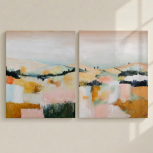 Díptico de cuadros abstractos inspirados en el paisaje de La Toscana, pintados a mano en tonos ocre, rosa pastel y verde, colgados sobre una pared minimalista beige claro con sombras de luz.